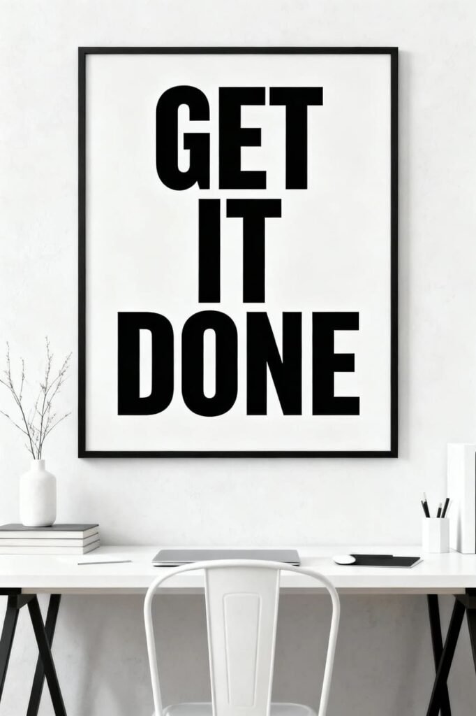 Bold black typography wall art reading “GET IT DONE” displayed in an office space.