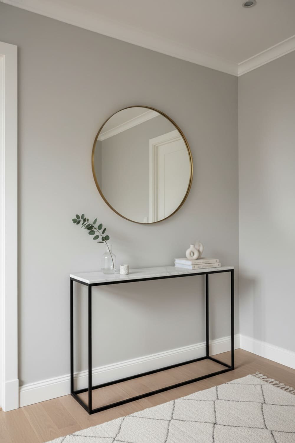Entryway with slim console table styled with a mirror and simple décor.