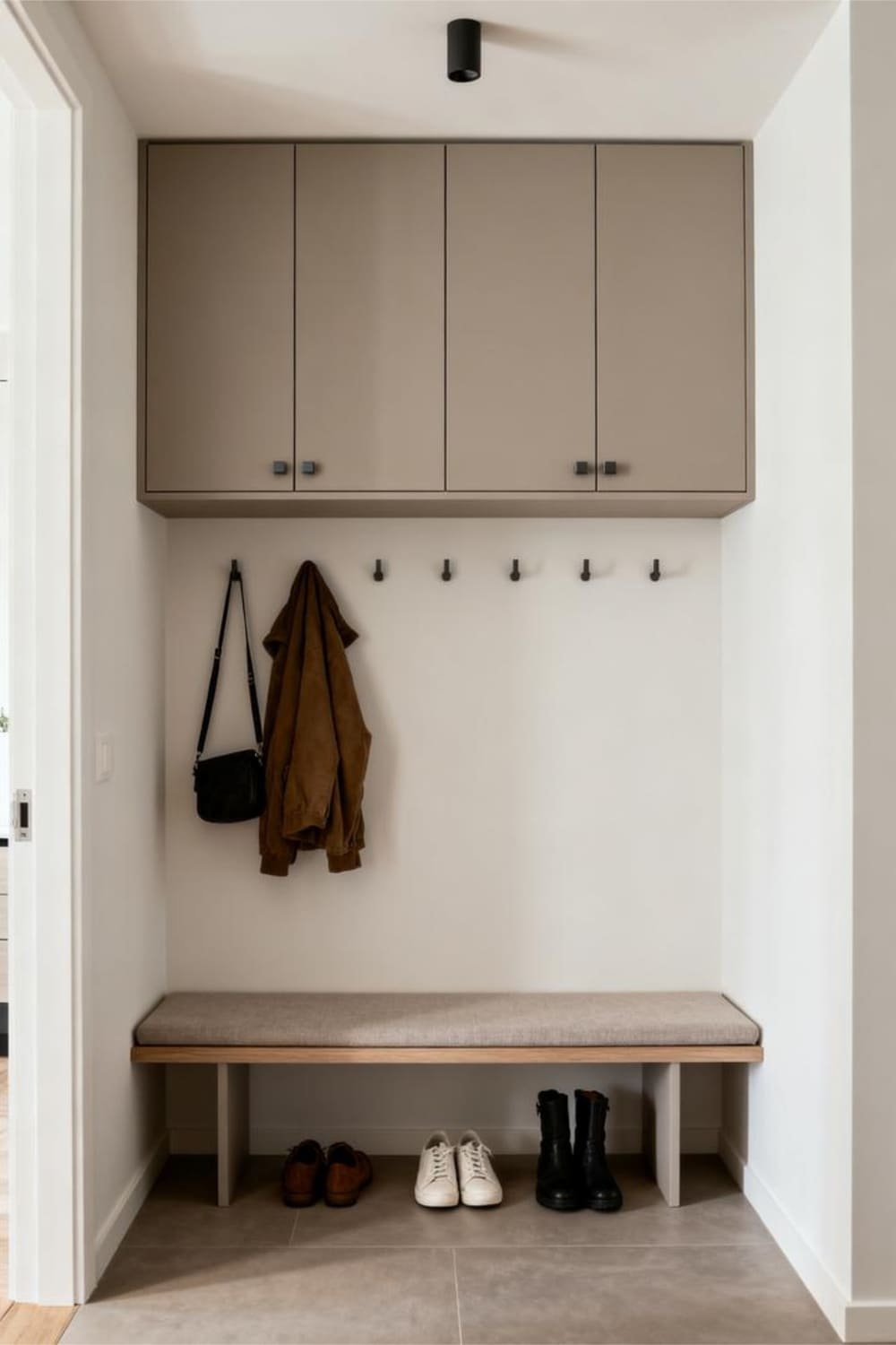 Shallow wall-mounted mudroom cabinets with smooth matte doors installed above a simple bench area.