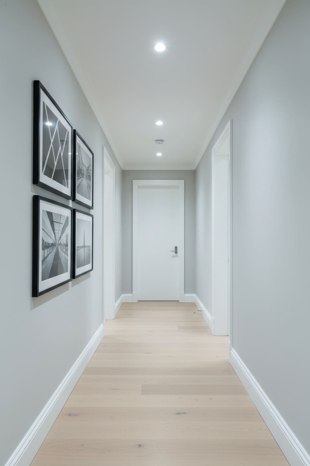 Light gray hallway with white trim and black framed artwork.